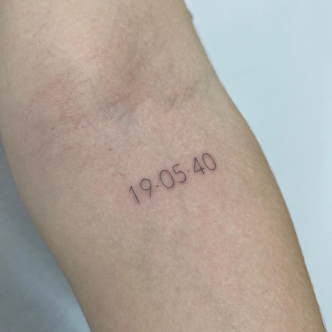 Tattoo numérico 19.05.40 en el antebrazo · Andrea @ads.ink